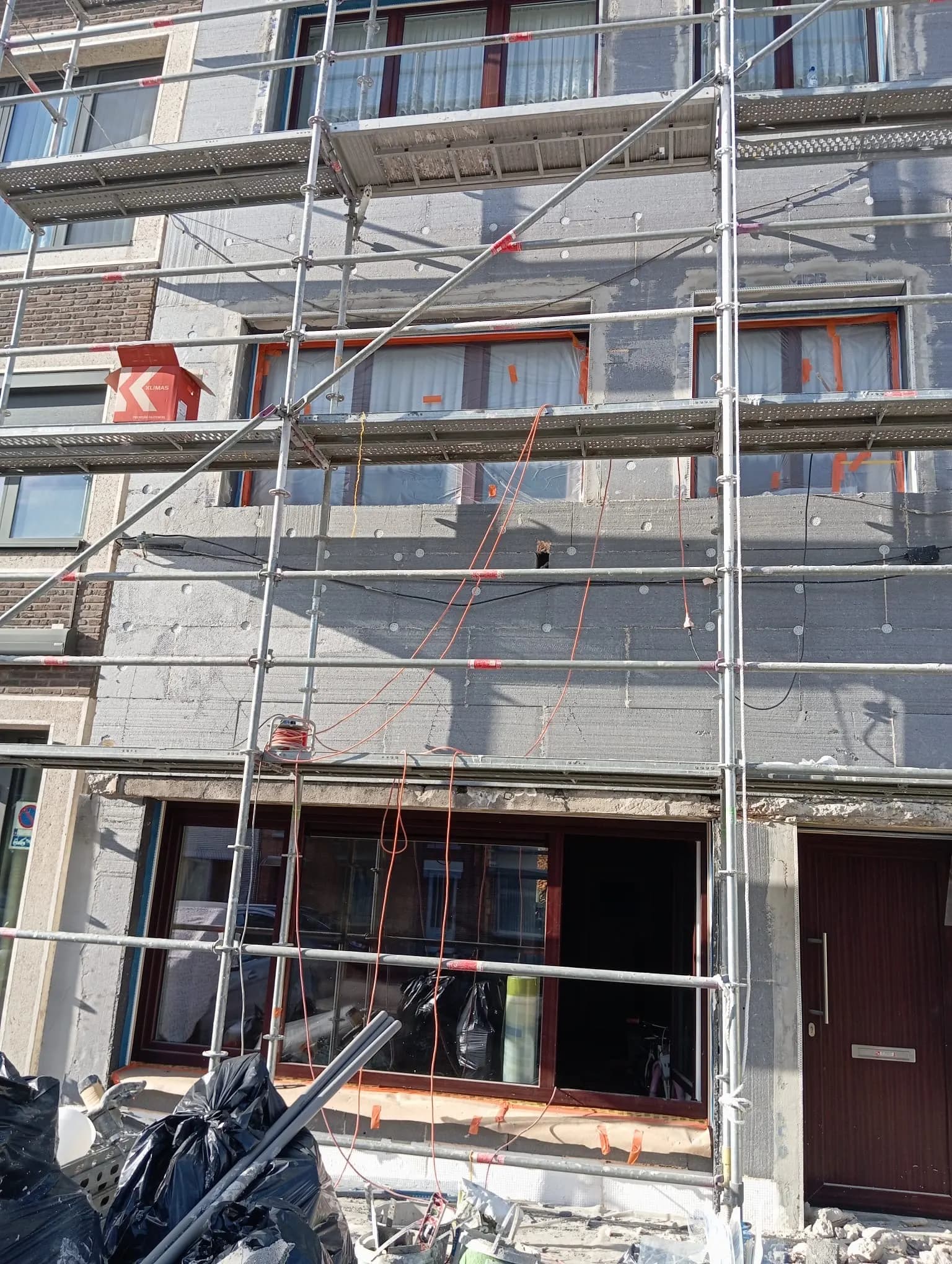 Gevel volledig bekleed met isolatieplaten en pluggen, klaar voor de wapeningslaag