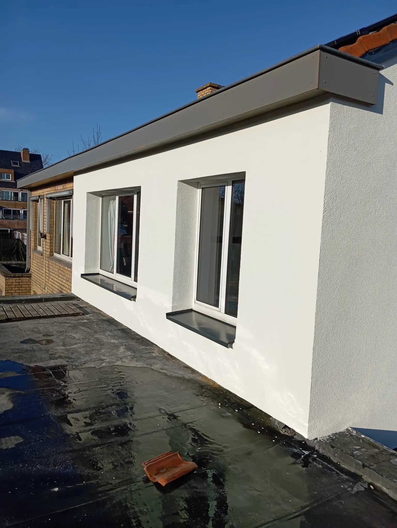 Dezelfde uitbouw met de witte crepi-eindafwerking en afgewerkte dakrand