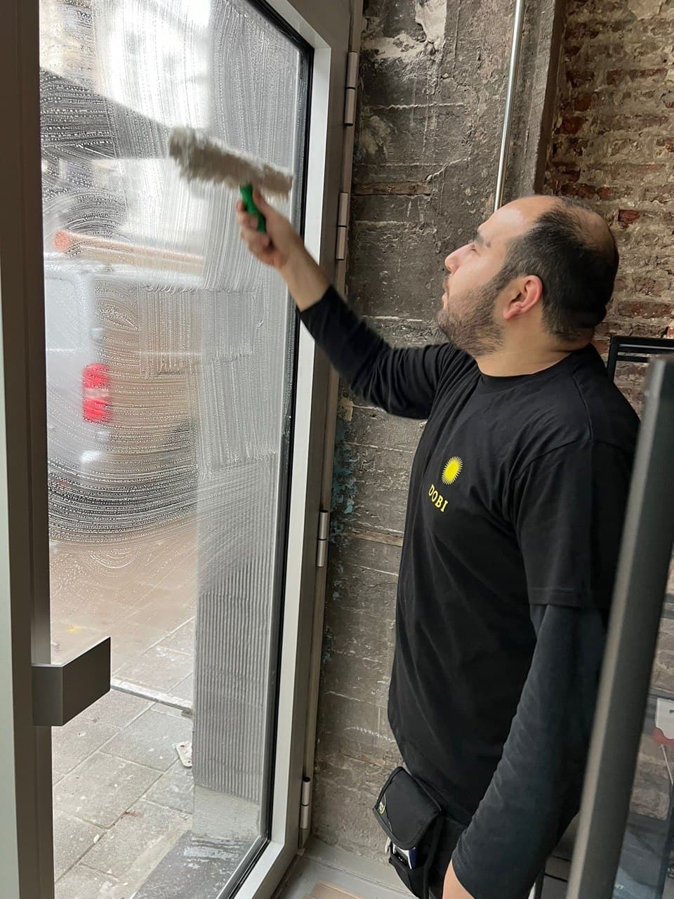 Glazenwasser Dobi Cleaning wast een raam binnen