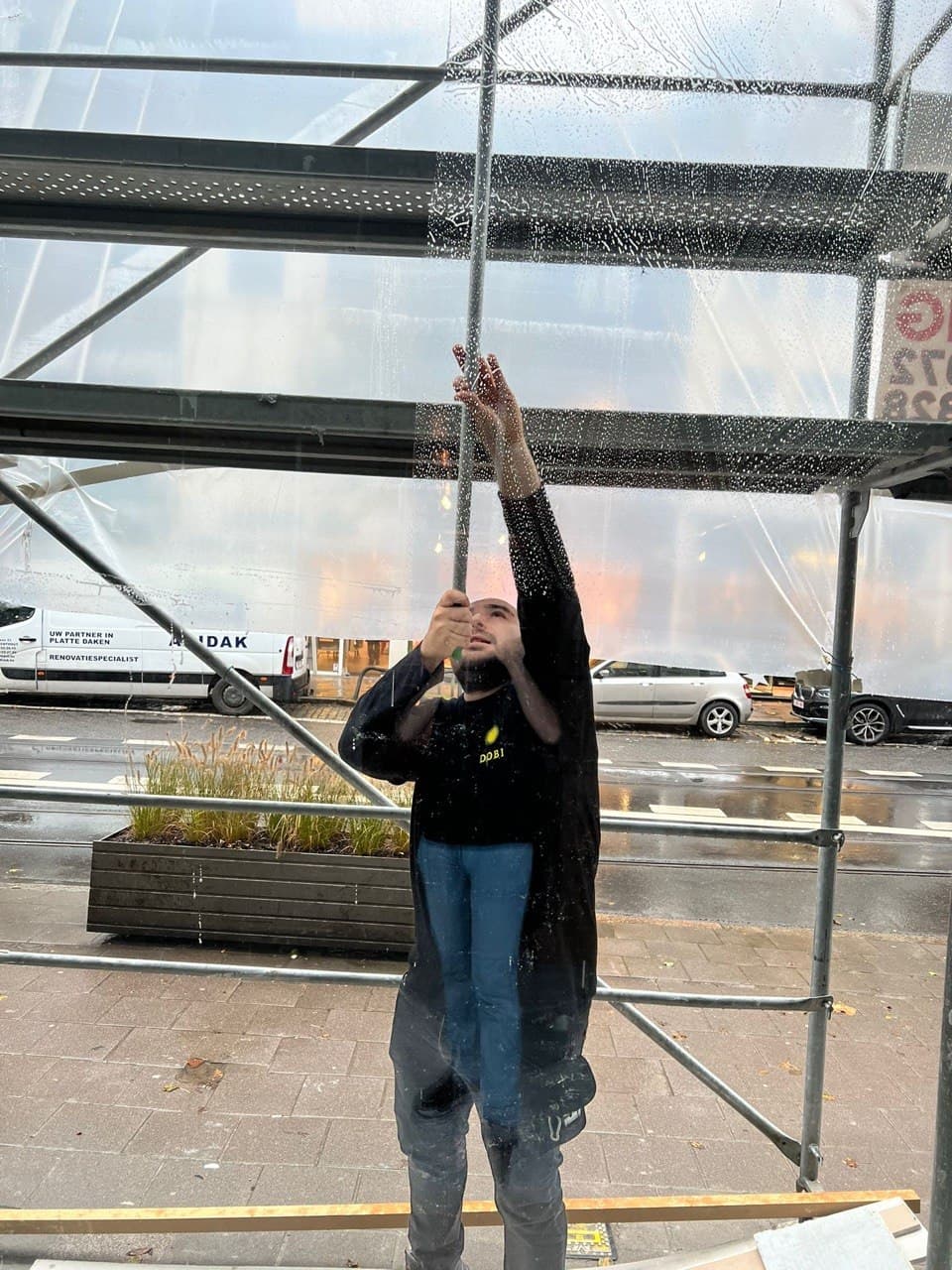 Medewerker Dobi Cleaning werkt aan de gevel op stelling
